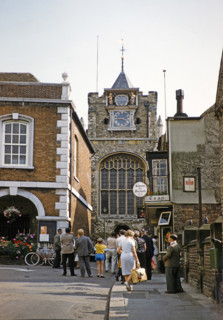 People in street walking by Simon the Pieman teashop towards parish church, Lion Street, Rye, Kent,