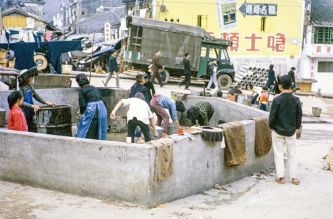 Women washing clothes in street  at public laundry place, Shun Tak Street, Tai Po, New Territories,