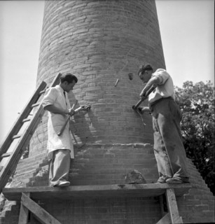 Explosive charge attachment before factory chimney blasting in Geneva 1943