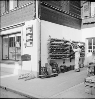 Baker puts loafs of bread on shelves outside the bakery, Brienz 1944