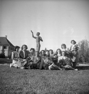 Women posing around the sculpture of a nude youth 1947