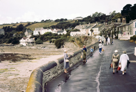 People walking on coastal promenade road.