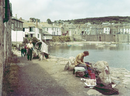 People on coastal path at seaside village of Mousehole.
