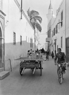 Cyclists and handcart in narrow alleyways street in old town Medina.