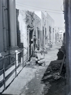 Workers with metal pots in narrow alleyway street in old town medina.