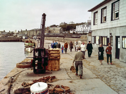People walking along the quayside in the  harbour at Hugh Town.