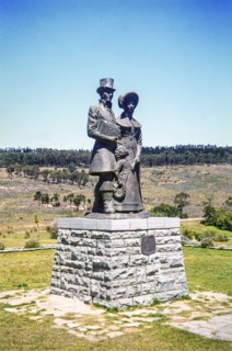 bronze statue of a Victorian-era settler family (a man, woman, and child) at the 1820 Settlers National Monument in Grahamstown (now Makhanda), South Africa.