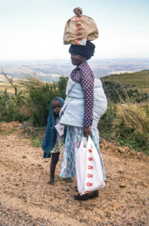 Woman with child and bay on her back.