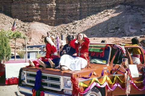 People sitting on GMC pickup truck.
