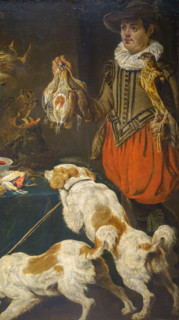Hunter with dogs at a table with poultry and fruit.