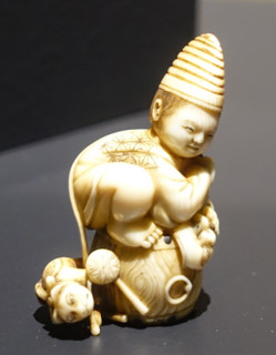 Okimono ""Karako with a mask and a toy cat, sitting on a drum"".