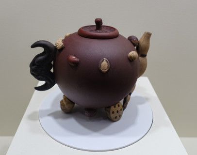 Teapot with images of nuts, a lotus seed pod with stem, a bat, and a mushroom.