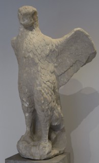 Eagle from a grave monument. The eagle turns its head towards a partially preserved snake that was