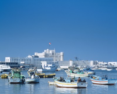 EGYPT, Nile Delta, Alexandria, Fishing boats moored in harbour with fortress castle and walls