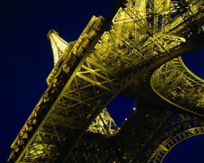 FRANCE, Ile de France, Paris, Eiffel Tower.  Angled view from below floodlit at night.