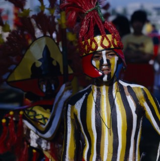 PHILIPPINES, Luzon, Manila, Boy at Ati-Atihan  festival with striped painted body and wearing a red