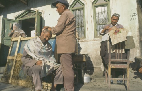 CHINA, Xinjiang Province, Kashgar, Men having their heads shaved by street barbers