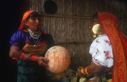 INDIA, San Blas Islands, Cuna Indian women washing clothes with one smoking a pipe