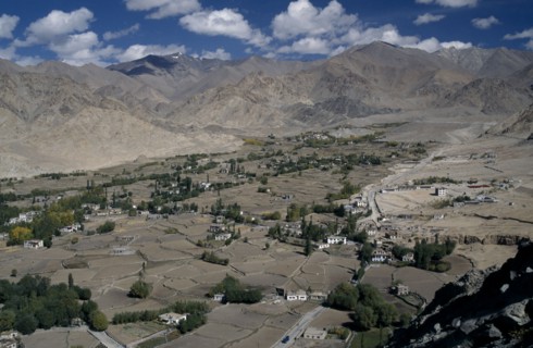 INDIA, Ladakh Region, View over valley with scattered houses and cultivated land surrounded by