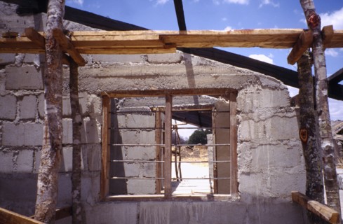 TANZANIA, Construction, Building site with unfinished block built house and barred window.