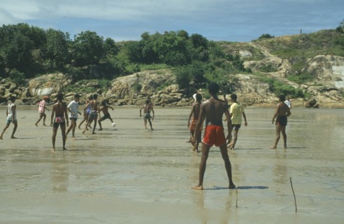 BRAZIL, Near Recife, Men playing football on the wet sand of the beach with sticks for goalposts