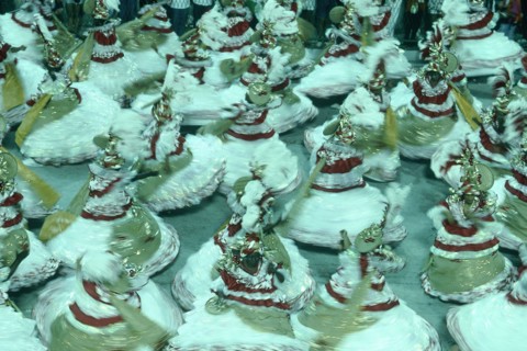 BRAZIL, Rio de Janeiro, Carnival dancers in red gold and white spinning around in procession