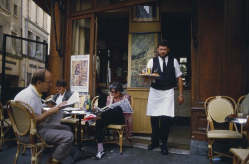 FRANCE, Ile de France, Paris,  A waiter carrying a tray with drinks to customers sat outside la