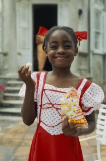 WEST INDIES, Barbados, Easy Hall, Young smiling girl in red and white dress with red ribbons in