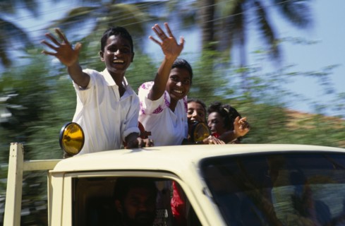 SRI LANKA, People, Children, Children waving from the back of a truck driven by man.
