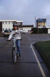 10013304 SPORT  Cyclists Girl wearing safety head gear  riding bike giving a hand signal.