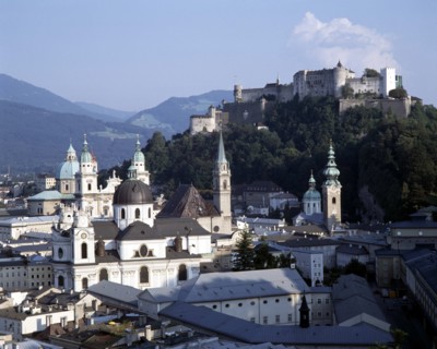 AUSTRIA, Salzburg Province, Salzburg, Hohensalzburg Fortress beyond town rooftops with wooded hills