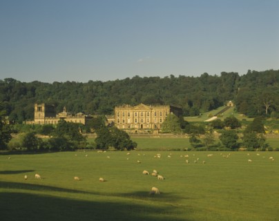 ENGLAND, Derbyshire, Chatsworth House, View towards exterior facade over grazing sheep in pasture