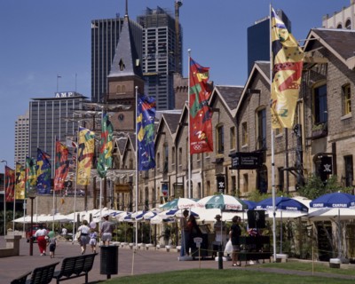 AUSTRALIA, New South Wales, Sydney, The Rocks harbourside area with people walking past restaurants