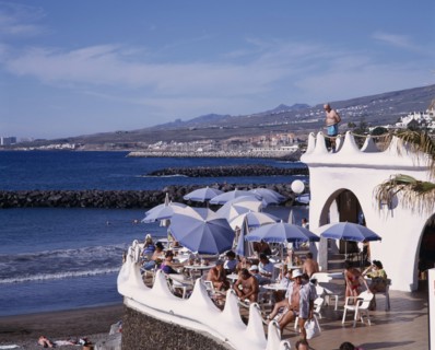 SPAIN, Canary Islands, Tenerife, Playa de las Americas. Terraced bar overlooking the beach with