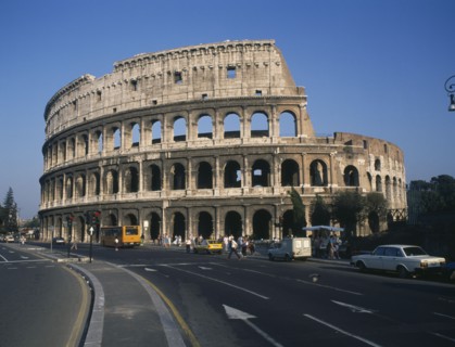 ITALY, Lazio, Rome, The Colosseum with road and passing traffic in foreground.