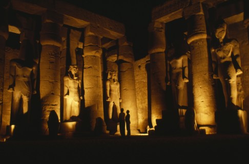 EGYPT, Luxor, The Temple illuminated at night with giant standing Statues of Rameses II
