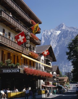 SWITZERLAND, Bern Oberland, Grindelwald, Main street and hotel e distance with flags on the