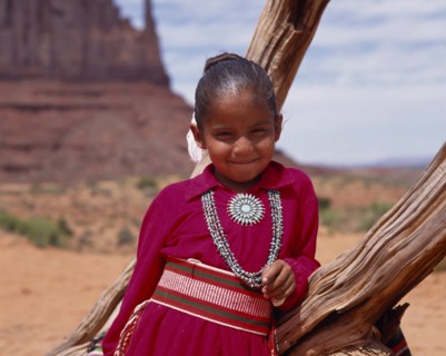 USA, Arizona, Monument Valley, Portrait of Navejo girl wearing a red dress and turquoise necklace