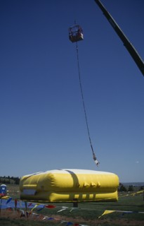 SPORT, Air, Bungee Jumping, Bungee jumper suspended from crane over inflated safety mat.