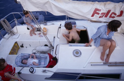 10031035 LEISURE Sailing Yachting Greece. View over a family on a sailing holiday aboard their yacht. Mother with children and a baby lying in a carry cot