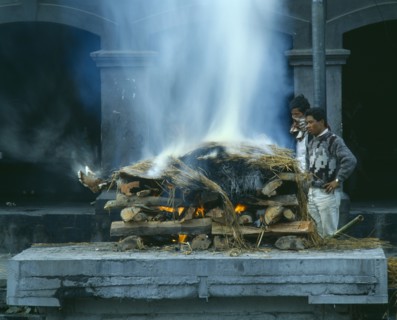 NEPAL, Kathmandu, Cremation ceremony.  Funeral pyre and burning body.