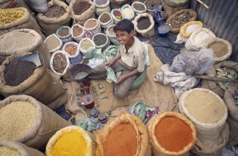 INDIA, Delhi , Spice market, View looking down on young vendor sitting at scales in the middle of