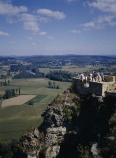 FRANCE, Aquitaine, Dordogne , Domme. People standing on a brick platform on a rocky hill looking