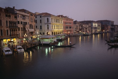 ITALY, Veneto, Venice, The Grand Canal at night with lights reflected in the water. Moored gondolas