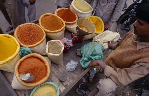 INDIA, Delhi , Looking down on stall in spice market with cropped view of male vendor and customers