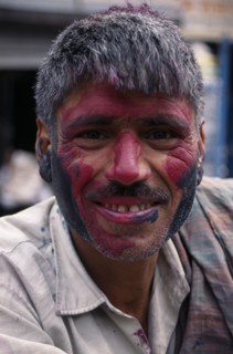 INDIA, Delhi, Head and shoulders portrait of man with face covered in pink and black coloured