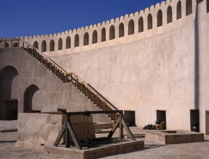 OMAN, Nizwa , Fort interior with cannons and cannon balls placed by the wall.