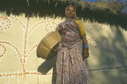 NEPAL, Madhya Pradesh, Janakpur , Mithila woman standing in front of painted house.