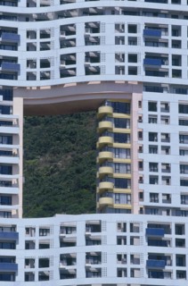 HONG KONG, Discovery Bay, Blue apartment building designed with a hole in it showing the green