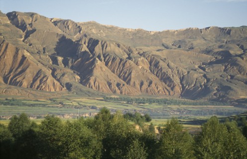 CHINA, Qinghai, General, Mountains behind trees and fields at the edge of the Tibetan plateau